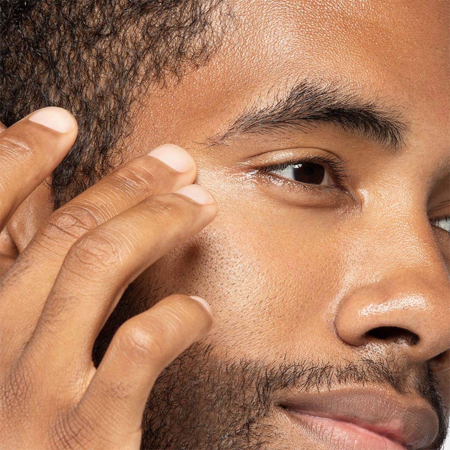 Man applying Awaken peptide eye gel to under eye