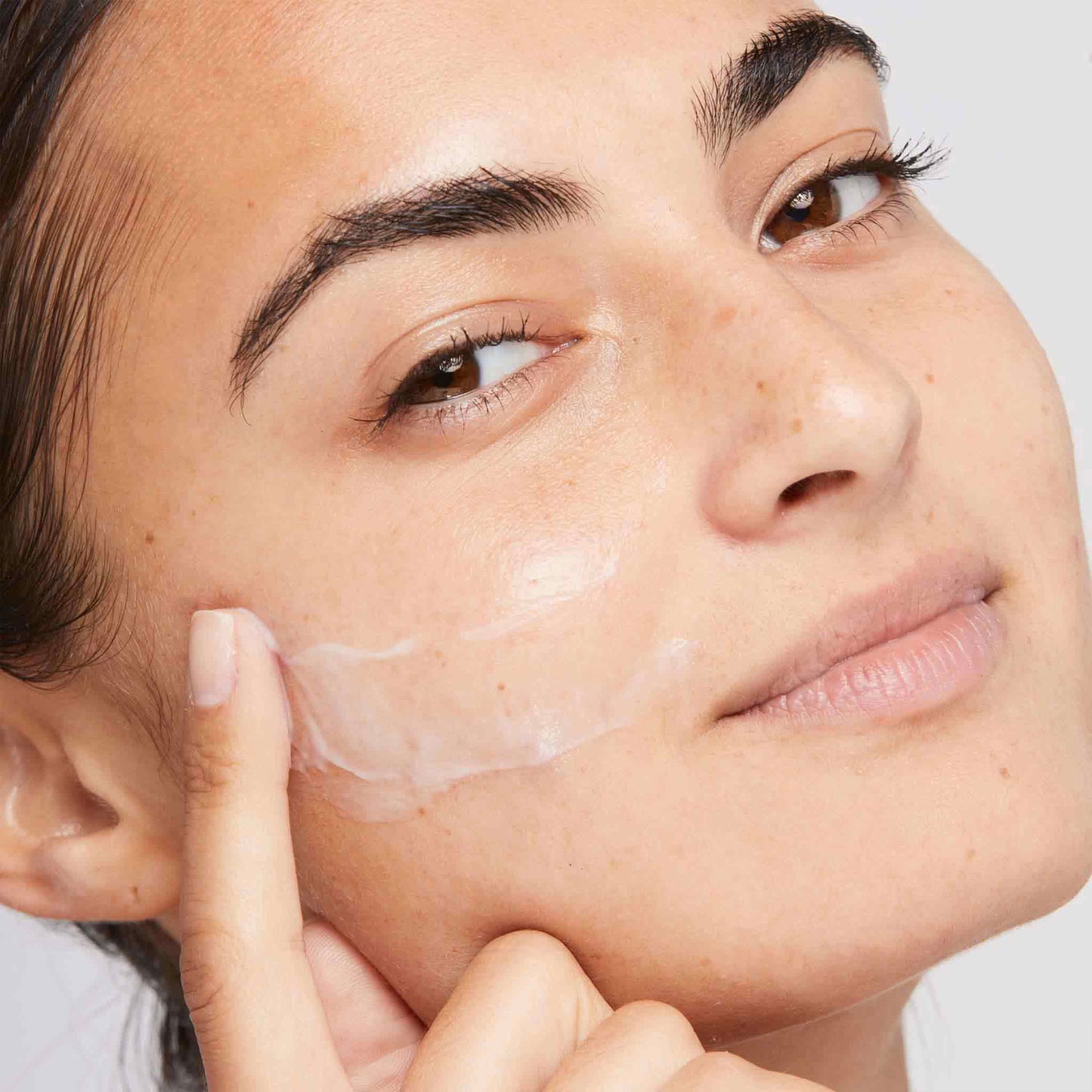 Model applying Active moist to face