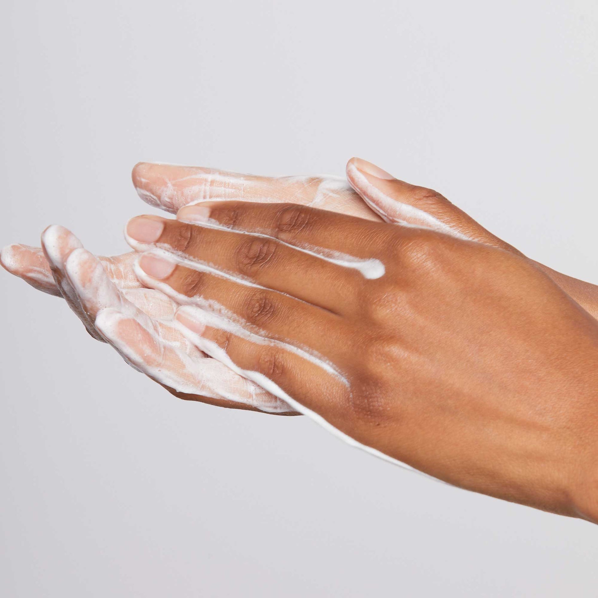 Daily Microfoliant powder being emulsified in wet hands, forming a light foam