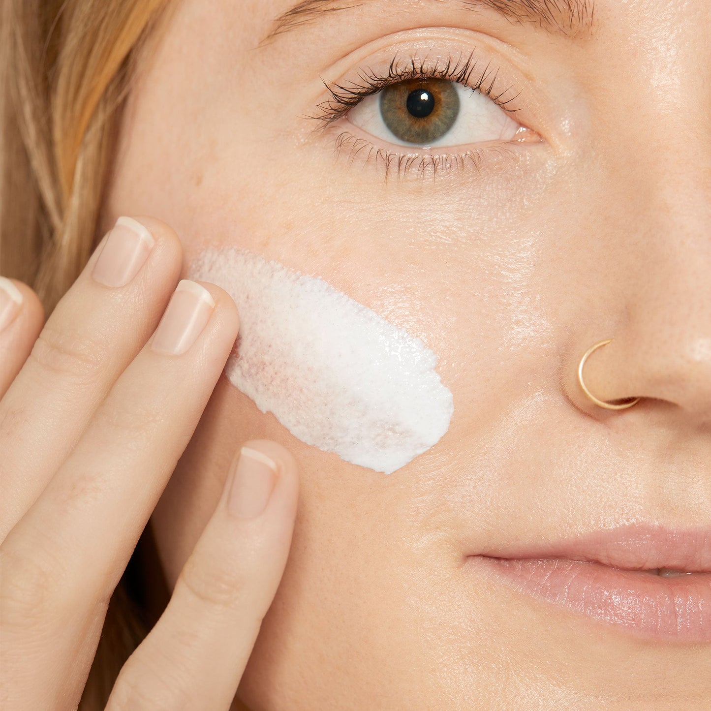 Woman applying porescreen SPF 40 to cheek