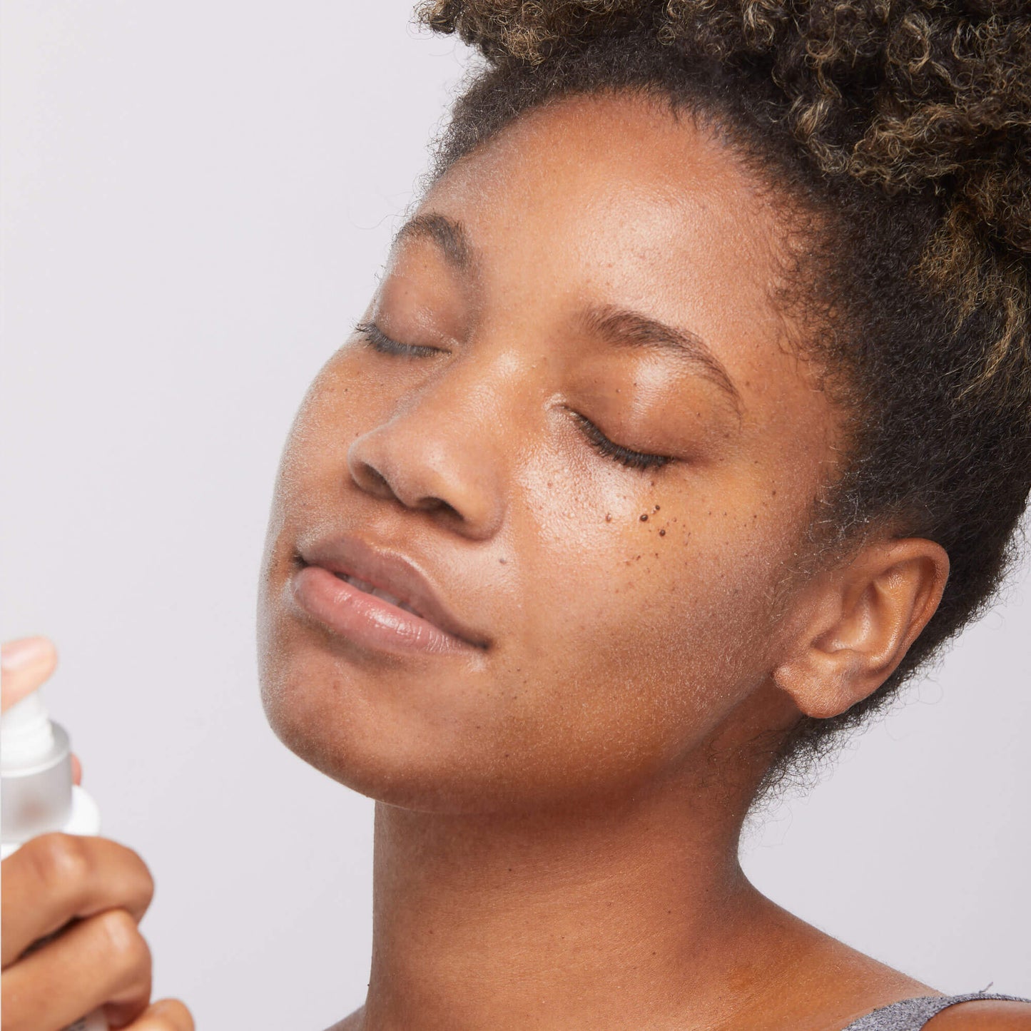 Antioxidant hydramist being sprayed onto model face