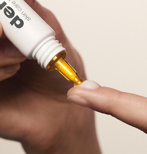 Biolumin-c eye serum being dispensed onto fingertip