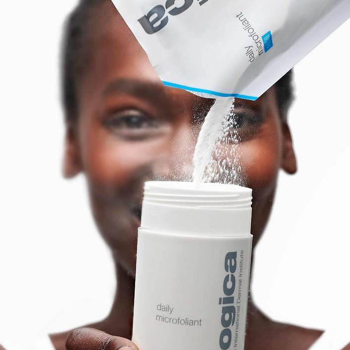 Daily Microfoliant refill pouch being poured into the full size bottle.