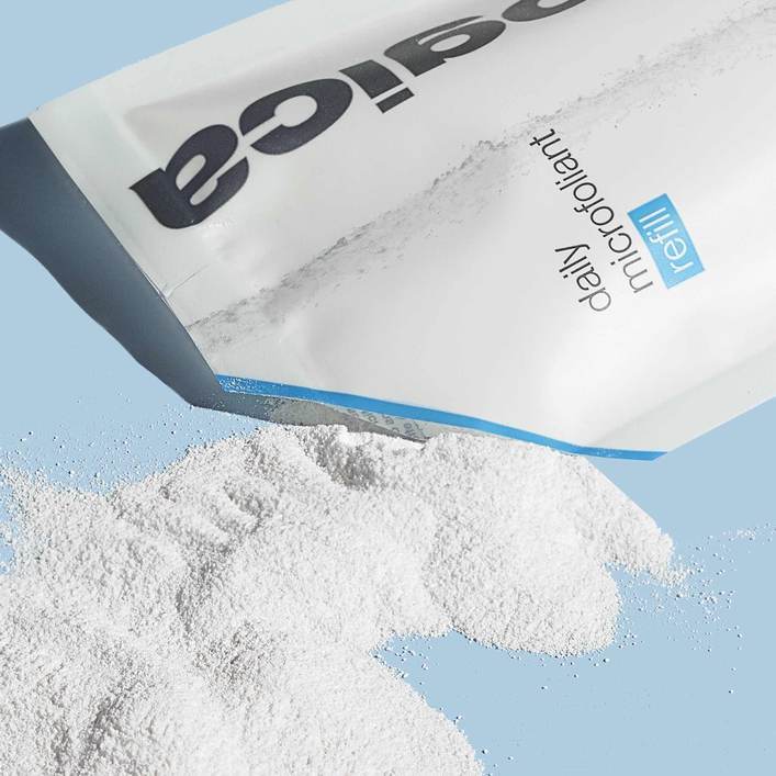 Daily Microfoliant pouch being poured onto a flat blue surface.